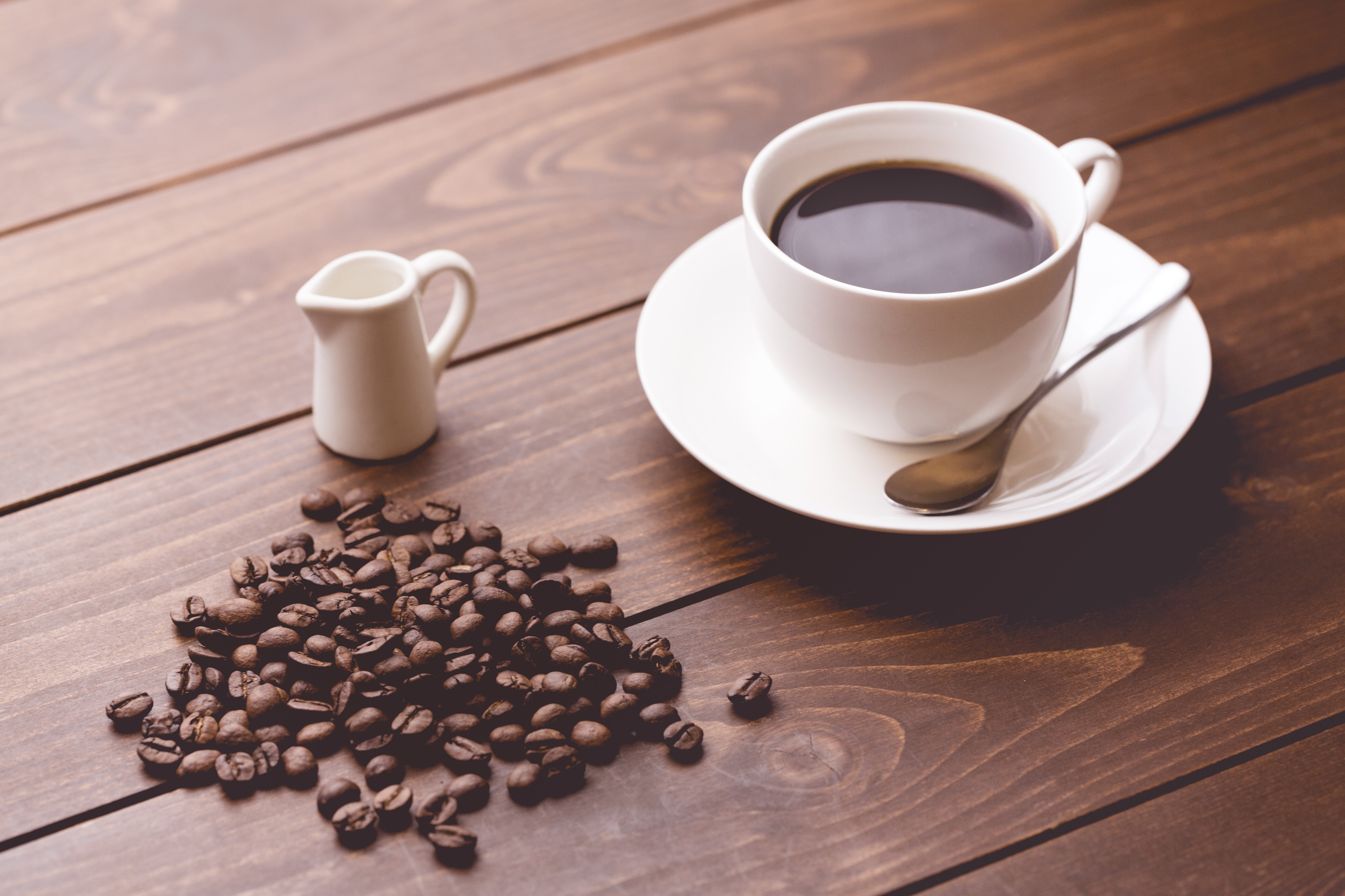 珈琲豆とホットコーヒーの画像